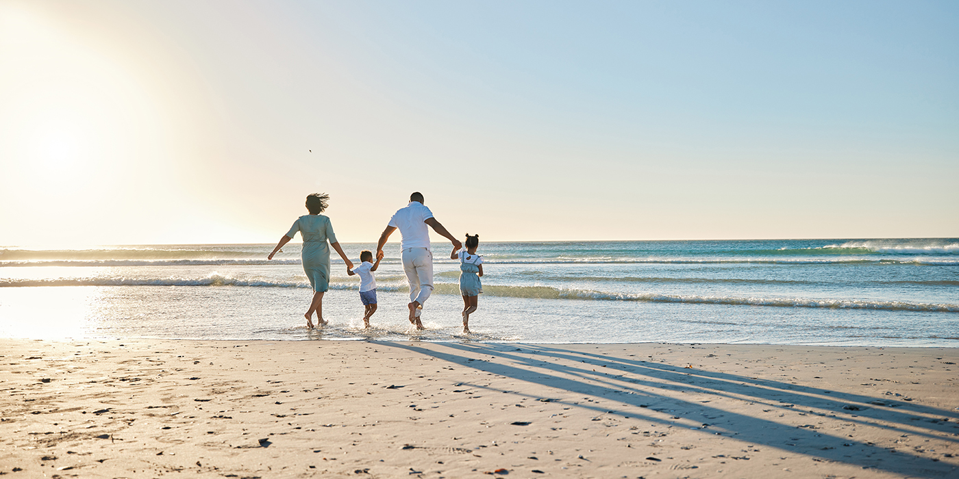 Lets go splish and splash. Rearview shot of a happy family walking towards the sea.