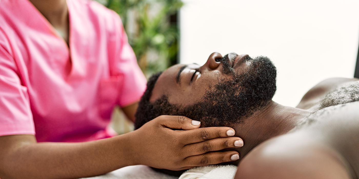 African american man reciving head massage at the clinic.